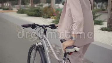 一个人骑自行车走路的女人。